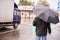 Overcast weather. Man with black umbrella. Blurred Background