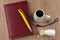 Overcoming sleepiness: Tablets of ephedrine, yellow pen, coffee, glasses and book on wooden table, top view