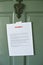 Overdue Notice Posted on a Door of a Home - Letter - Late Payment - Rent - Mortgage - Green Front Door with Knocker