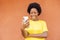 Overexcited African-American female with afro hair using a modern smartphone checking social media