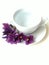 Overexposed, blurred, white Cup with clean water, on the saucer under the Cup lies a violet boutonniere, drinking water