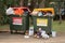 Overfilled garbage wheelie bins with colourful lids