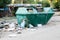 Overfilled trash dumpster in ghetto neigborhood outdoors