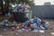 Overflowing dumpster with rubbish lying around