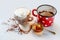 Overflowing milk foam from cup with cocoa drink, sprinkled dirty background, honey with spoon and red-white dotted pot