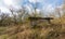 Overgrown concrete bridge pier in a natural landscape