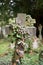 Overgrown cross in cemetery