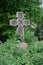 Overgrown cross gravestone