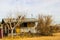 Overgrown One Level Home With Boarded Up Windows & Door