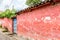 Overgrown red, weathered house exterior, Central America