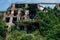 Overgrown ruins of abandoned school with bullet marks, consequences of war in Abkhazia