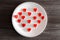 Overhead above top close up view photo of yummy tasty cute gummy red small little tiny hearts in on round white plate on kitchen s