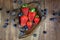 Overhead Display of Fresh Strawberries and Blueberries in a Rustic Wood Bowl