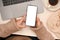 Overhead, Female in cozy brown sweater using a smartphone at her office desk