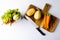 Overhead of knife and vegetables on chopping board with vegetable waste in kitchen composting bin