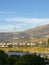 Overhead line pylons, high voltage pylons in meadow with mountains on background