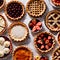 Overhead photo of different pies, tarts, and deserts on white marble table