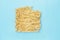 An overhead photo of egg noodles on blue background