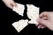 An overhead photo of Jewish child and men hands hold matza, leavened bread isolated on black background. Hands holding matzah for