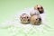 An overhead photo of quail eggs and white feathers, rustic background. A photo from above of small uncooked quail eggs on the ligh