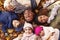 Overhead Portrait Of Family Lying In Autumn Leaves