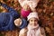 Overhead Portrait Of Three Children Lying In Autumn Leaves