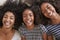 Overhead Portrait Of Three Teenage Sisters Lying On Bed At Home