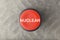 Overhead of Red Nuclear Push Button Over Blurred Gray Background