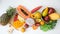 Overhead shot of assortment of exotic fruits and leaves on white background