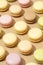 overhead shot of a beige table surface featuring an array of colorful macarons in neat rows