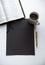 Overhead shot of a black rectangle on a white surface near a Bible, coffee and a pen