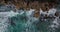 Overhead shot of The bluish ocean waves crashing against the rocks