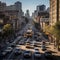 An overhead shot of a busy city street during rush hour, with cars zooming by and people rushing t