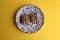 Overhead shot of delicious square biscuits with chocolate cream on a decorative plate