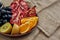 Overhead shot of a full plate of juicy, sliced fruits on wooden plate