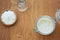 An overhead shot of a glass jar containing bubbling sourdough, flour and water on a warm oak wooden background