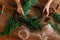 Overhead shot of hands making handmade Christmas wreath with twigs, pine cones, cinnamon sticks