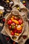 Overhead shot of homegrown assorted red, yellow, orange tomatoes in wicker straw basket