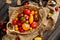 Overhead shot of homegrown assorted red, yellow, orange tomatoes in wicker straw basket