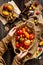 Overhead shot of homegrown assorted red, yellow, orange tomatoes in wicker straw basket in woman hands