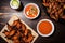 overhead shot of ipa, grilled wings plate, and hot sauce dropper