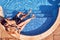 Overhead Shot Of Loving Couple In Swimsuits Relaxing In Outdoor Swimming Pool