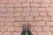 Overhead shot of man standing on brick patterned flooring