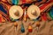 overhead shot of maracas, sombrero and mexican poncho on a sandy beach