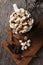 Overhead shot of a mug of hot cocoa with toasted marshmallows next to a cutting board with chocolate chunks and cinnamon sticks.