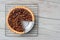 Overhead shot of a pecan pie with a slice cut out on a cooling rack. Horizontal format on a rustic whtie kitchen table