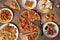 Overhead shot a restaurant table with sliced pizza surrounded by delicious snacks and appetizers