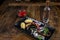 Overhead shot of  roasted octopus and vegetables, rustic background and bottle of ouzo drink