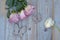 Overhead shot of roses on a blueish wooden surface with butterfly figures on it