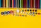 Overhead shot of stationery. Frame of school supplies on yellow paper